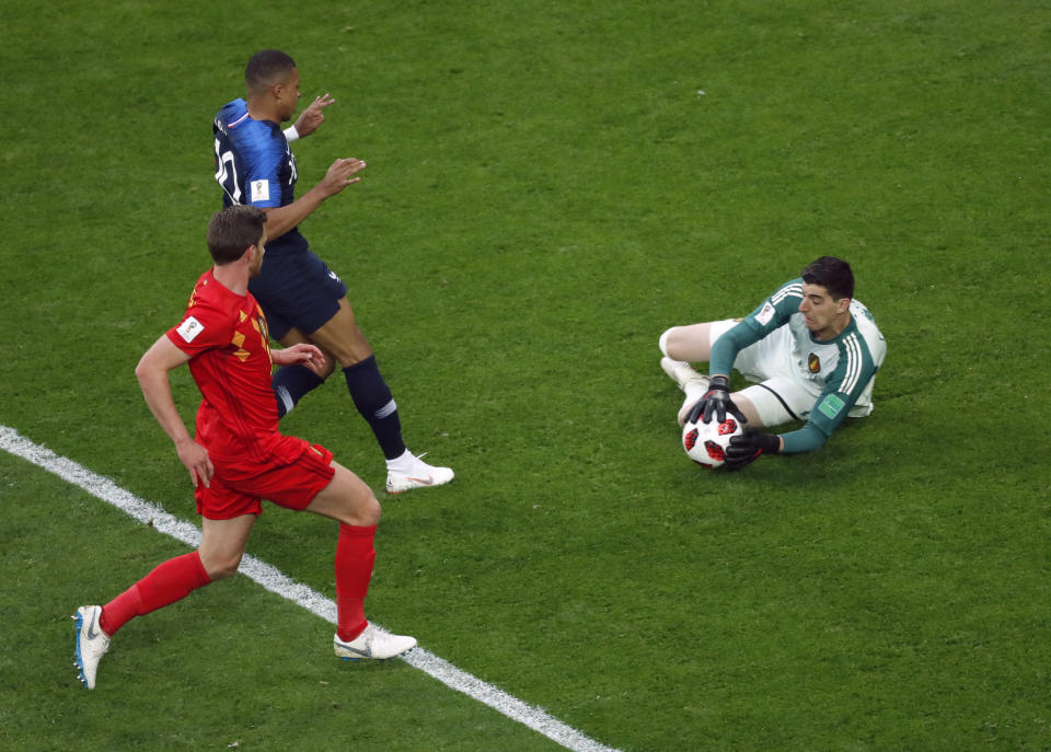 <p>Belgium goalkeeper Thibaut Courtois smothers any danger as Kylian Mbappe lurked </p>