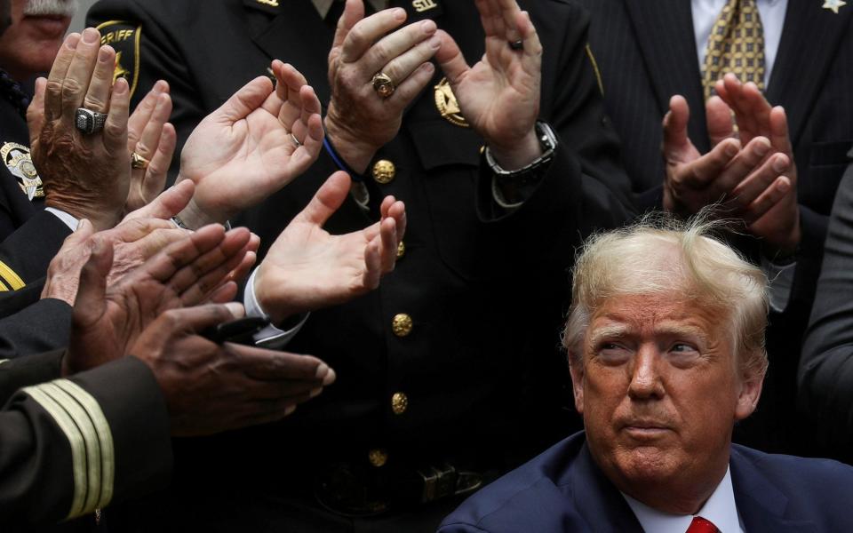 President Donald Trump listens to applause after signing an executive order in 2020 - REUTERS/Leah Millis