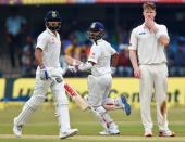 Cricket - India v New Zealand - Third Test cricket match - Holkar Cricket Stadium, Indore, India - 08/10/2016. India's Ajinkya Rahane (C) and Virat Kohli (L) run between wickets as New Zealand's James Neesham looks on. REUTERS/Danish Siddiqui