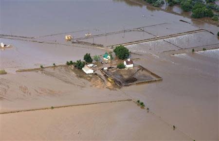 An aerial view of a farm house surrounded by flood waters along the South Platte River near Greenley, Colorado September 14, 2013. REUTERS/John Wark