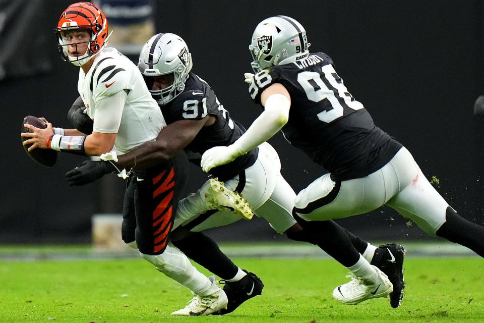 Cincinnati Bengals quarterback Joe Burrow (9) is sacked by Las Vegas Raiders defensive end Yannick Ngakoue (91) in the second quarter during a NFL Week 11 game, Sunday, Nov. 21, 2021, at Allegiant Stadium in Las Vegas.