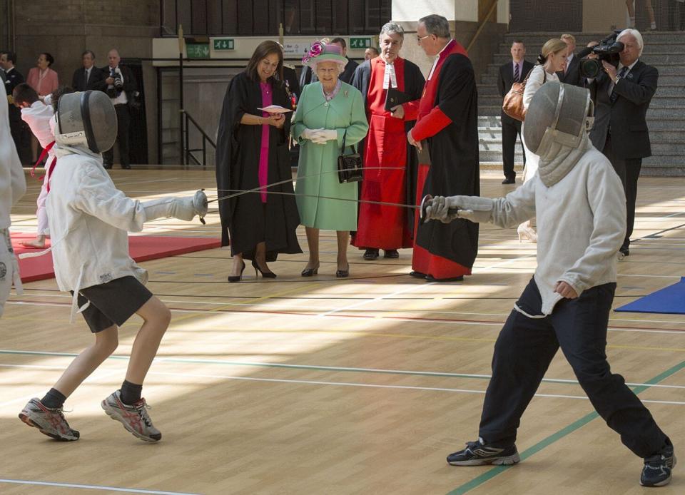 Queen Elizabeth II watches pupils fencing at the sports centre that she officially opened at Westminster School in London on June 12, 2014. 