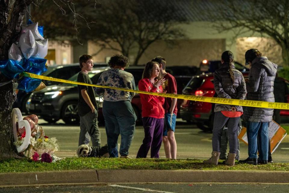 A group of people talk near a memorial for the victims of a mass shooting in Chesapeake, Virginia.