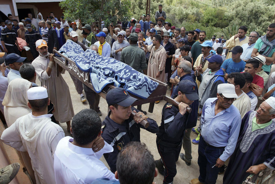 Security forces carry the body of a man who died in a flash flood in Tizert, near the southern region of Taroudant, Morocco, Thursday, Aug. 29, 2019. Morocco's official MAP news agency says that seven people watching a local soccer match in a southern village have died in a flash flood that swept across a football field on Wednesday evening. (AP Photo/Mohamed Amerkad)