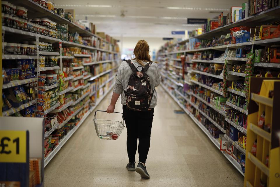 <p>A shopper browses an aisle for groceries at a Tesco Superstore in south London</p> (AFP via Getty Images)