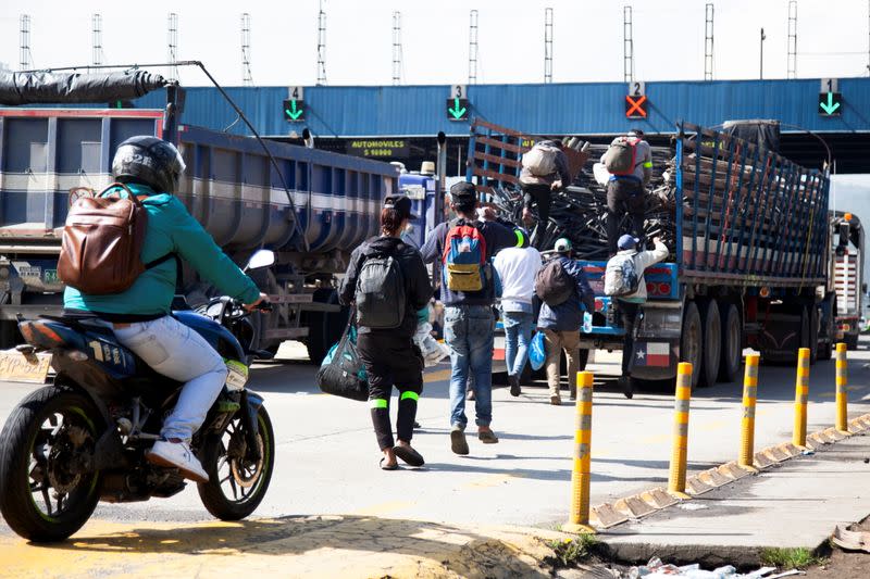 Venezuelan migrants get on a truck that will give them a lift on a highway in Chusaca
