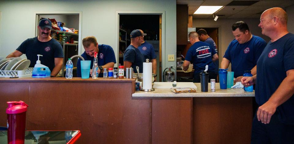 Westfield Fire Department B-shift members laugh and joke with each other Thursday, July 21, 2022, as they clean  after lunch. Everyone helps out and takes turns cooking and cleaning. 