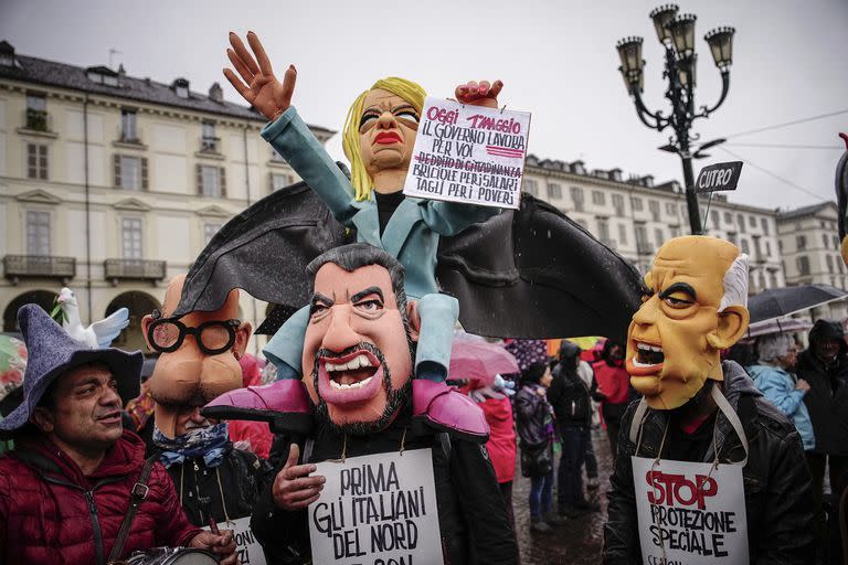 Manifestantes llevan cabezas de marionetas de la primera ministra italiana, Giorgia Meloni, Matteo Salvini, ministro de Infraestructuras y Transportes, y Matteo Piantedosi, ministro del Interior, durante una marcha del Primero de Mayo, en Turín, Italia, el lunes 1 de mayo de 2023.