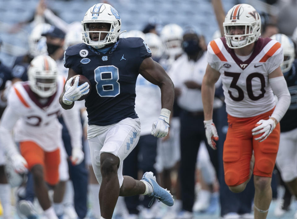 North Carolina's Michael Carter (8) breaks away from Virginia Tech's Tyler Matheny (30) for a 62-yard touchdown in the fourth quarter of an NCAA college football game, Saturday, Oct. 10, 2020 at Kenan Stadium in Chapel Hill, N.C. (Robert Willett/The News & Observer via AP)