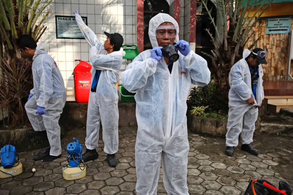 Health officials don their protective suits as they prepare to disinfect a mosque ahead of the Friday prayer in the wake of the new coronavirus, in Jakarta on March 13. The vast majority of people recover from the new virus.