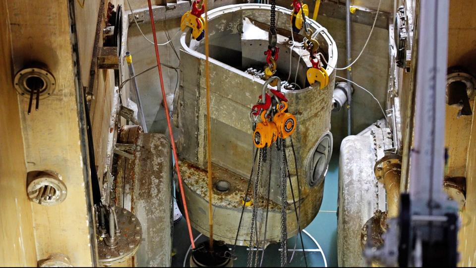 Crews used a large diamond saw to cut the final pieces that held the lower reactor vessel in place at the bottom of the Oak Ridge Research Reactor pool. This photo shows the final segment of the reactor being lifted from the pool area.