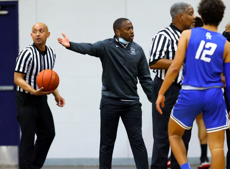 Santa Margarita basketball coach Justin Williams-Bell, center, reacts from the sideline during a game.