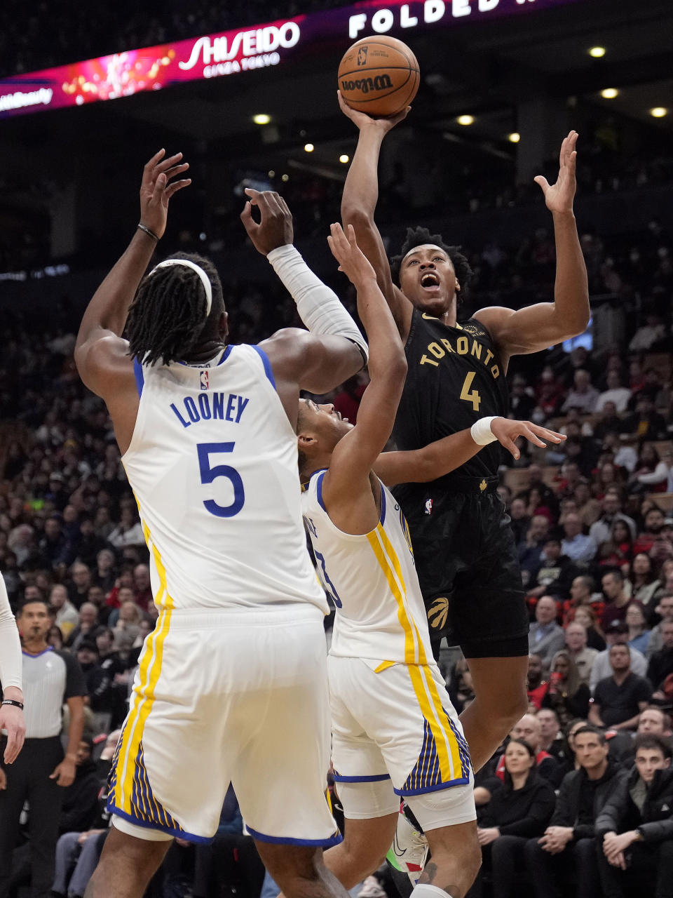 Toronto Raptors forward Scottie Barnes (4) goes for a layup as Golden State Warriors center Kevon Looney (5) and Jordan Poole (3) defend during first-half NBA basketball game action in Toronto, Sunday, Dec. 18, 2022. (Frank Gunn/The Canadian Press via AP)