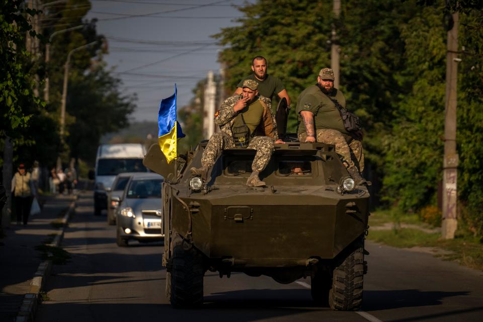 Ukrainian army soldiers sit on an armor military vehicle as they drive in Bucha, near Kyiv, Ukraine, Thursday, Sept. 8, 2022.