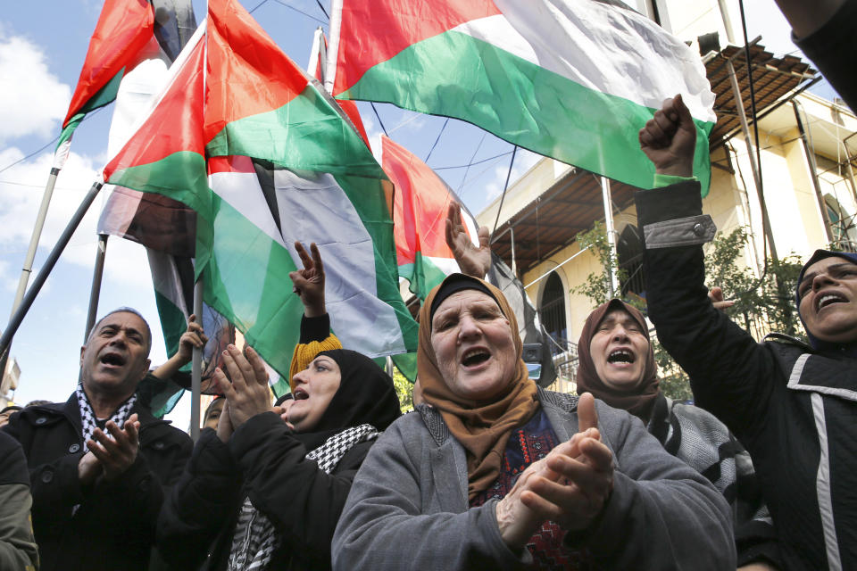 Palestinians chant slogans as they hold Palestinian flags, during a protest against the White House plan for ending the Israeli-Palestinian conflict, at Burj al-Barajneh refugee camp, south of Beirut, Lebanon, Friday, Jan. 31, 2020. (AP Photo/Bilal Hussein)