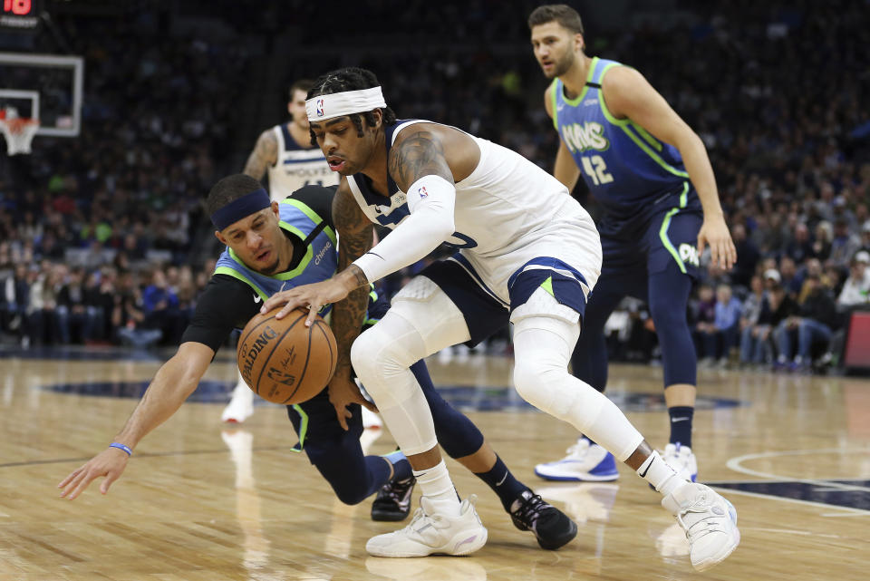 Minnesota Timberwolves' D'Angelo Russell handles the ball against Dallas Mavericks' Seth Curry in the first half of an NBA basketball game Sunday, March 1, 2020, in Minneapolis. (AP Photo/Stacy Bengs)