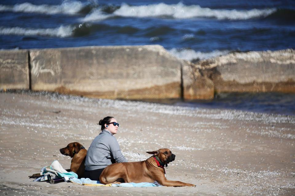 Lauren sits with her dogs at Deland Park while taking in the summer-like warmth, Wednesday, April 12, 2023, in Sheboygan, Wis.