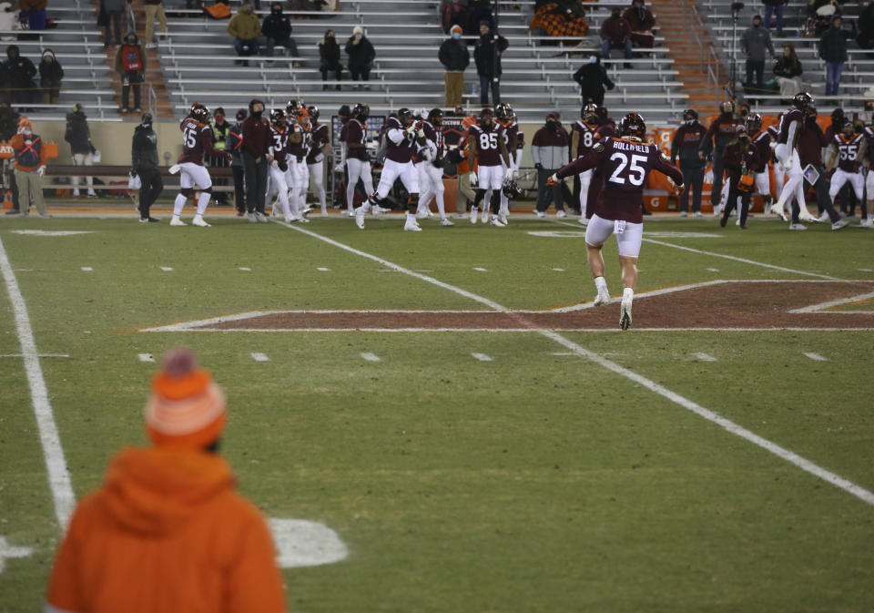 Virginia Tech's Jarrod Hewitt (25) dances near midfield after a portion of the field's sprinkler system was activated in the first quarter of the team's NCAA college football game against Clemson on Saturday, Dec. 5, 2020, in Blacksburg, Va. (Matt Gentry/The Roanoke Times via AP, Pool)