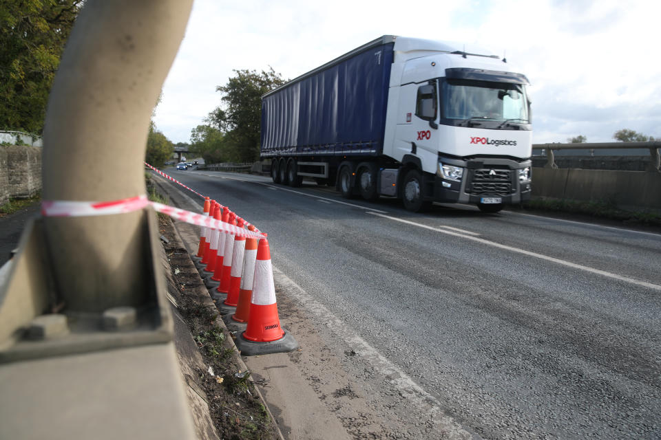 Cones and a warning tape surround damage on the road. (PA)