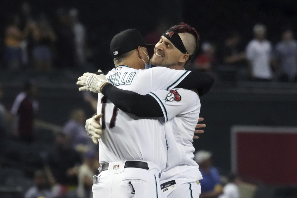 Arizona Diamondbacks' Josh Reddick hugs manager Torey Lovullo (17) after hitting a two-run double against the New York Mets in the 10th inning of a baseball game Tuesday, June 1, 2021, in Phoenix. The Diamondbacks won 6-5. (AP Photo/Rick Scuteri)