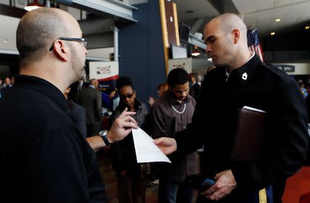 David Wallace (L) of Lockheed Martin interviews an applicant at a job fair for veterans and their spouses held by the U.S. Chamber of Commerce and the Washington Nationals baseball club at Nationals Park in Washington December 5, 2012. REUTERS/Gary Cameron