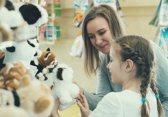 A mother and daughter pick out toys.