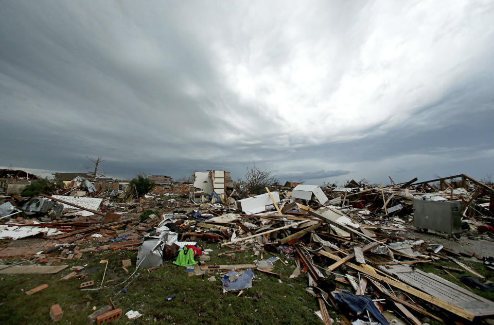 <p>Storm clouds build in the distance beyond tornado-ravaged homes Tuesday, May 21, 2013, in Moore, Okla. A huge tornado roared through the Oklahoma City suburb Monday, flattening entire neighborhoods and destroying an elementary school with a direct blow as children and teachers huddled against winds. (AP Photo/Charlie Riedel)</p>