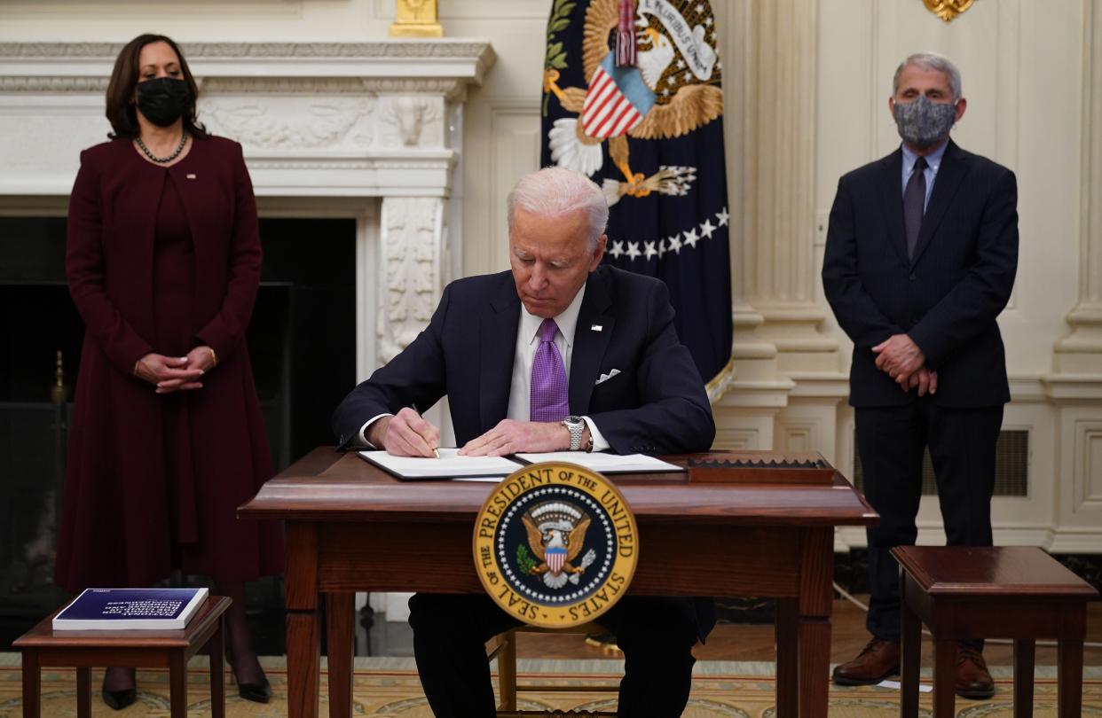 President Joe Biden signs executive orders on Jan. 21 as part of the COVID-19 response as Vice President Kamala Harris (left) and infections disease expert Dr. Anthony Fauci look on. (Photo: MANDEL NGAN via Getty Images)