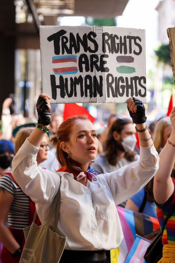 A protester at a rally holds a sign saying, 'Trans Rights are Human Rights'