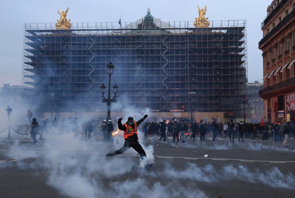 A protester kicks a tear gas canister in front of the Palais Garnier during Thursday’s protesters (Aurelien Morissard/AP)