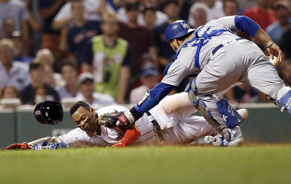 Los Angeles Dodgers' Russell Martin (55) tags out Boston Red Sox's Rafael Devers at home plate during the fifth inning of a baseball game in Boston, Sunday, July 14, 2019. (AP Photo/Michael Dwyer)