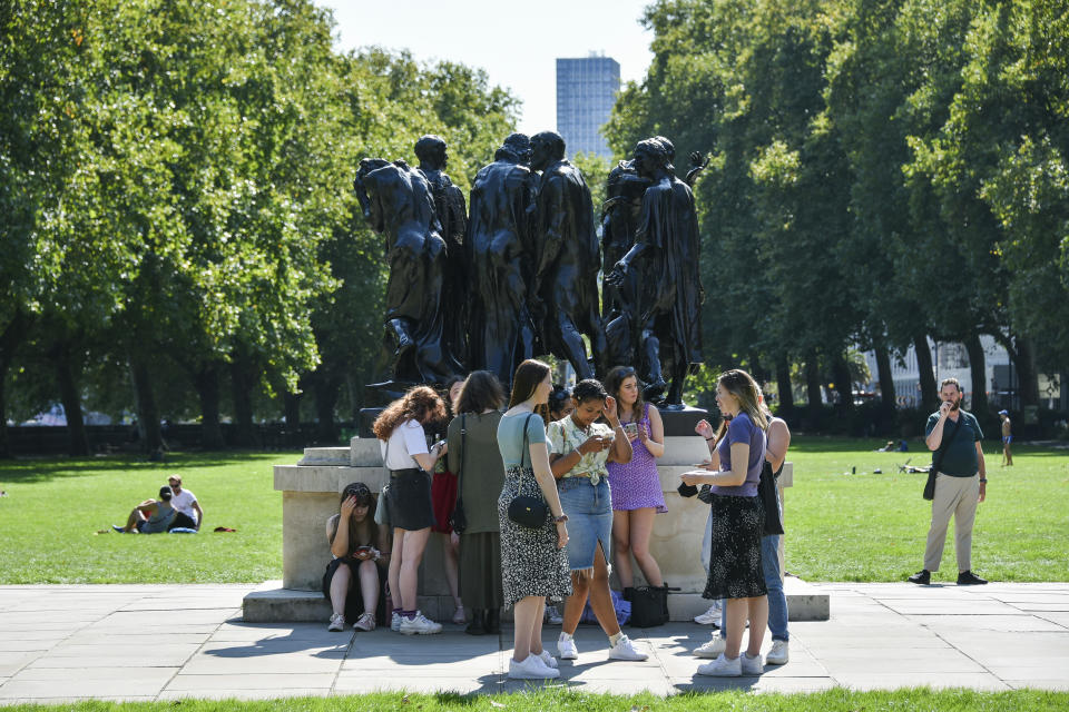 A group of people walk in Victoria Gardens, in London, Sunday, Sept. 13, 2020. From Monday, social gatherings of more than six people will be banned in England — both indoors and outdoors — and Boris Johnson hinted that such restrictions will potentially remain in place until or through Christmas. (AP Photo/Alberto Pezzali)