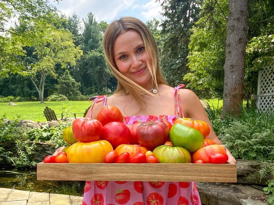 Meredith Hayden holding tomatoes in a tomato dress