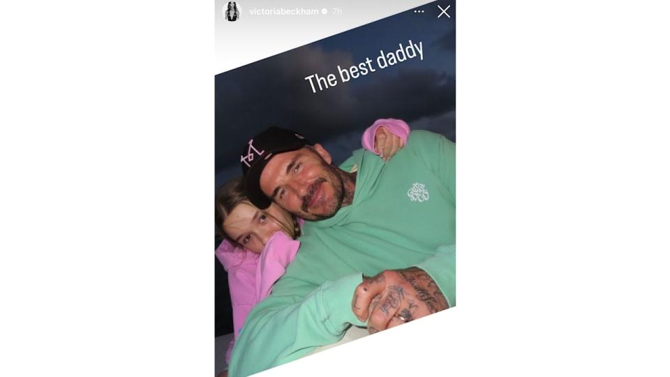 Harper Beckham wearing a pink sweater with dad David 