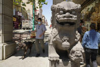 People make their way past the Dragon Gate southern entrance to Chinatown in San Francisco, Monday, May 23, 2022. Chinatowns and other Asian American enclaves across the U.S. are using art and culture to show they are safe and vibrant hubs nearly three years after the start of the pandemic. From an inaugural arts festival in San Francisco to night markets in New York City, the rise in anti-Asian hate crimes has re-energized these communities and drawn allies and younger generations of Asian and Pacific Islander Americans. (AP Photo/Eric Risberg)