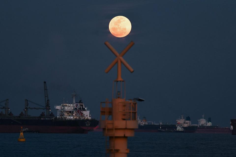 The full moon rises as the June 2022 "Strawberry Supermoon" in Singapore on June 14, 2022.