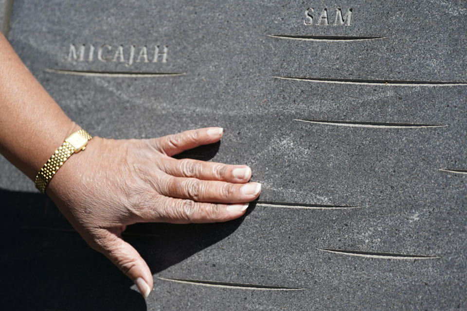 Cauline Yates, descendant of one of Thomas Jefferson's slave mistresses, points out names inscribed in the walls of the Memorial to Enslaved Laborers at the University of Virginia in Charlottesville, Va., Thursday, May 6, 2021. “It’s time for them to stand up and honor our ancestors,” said the Charlottesville resident, who recently co-founded a group advocating for UVA's slave descendants. (AP Photo/Steve Helber)