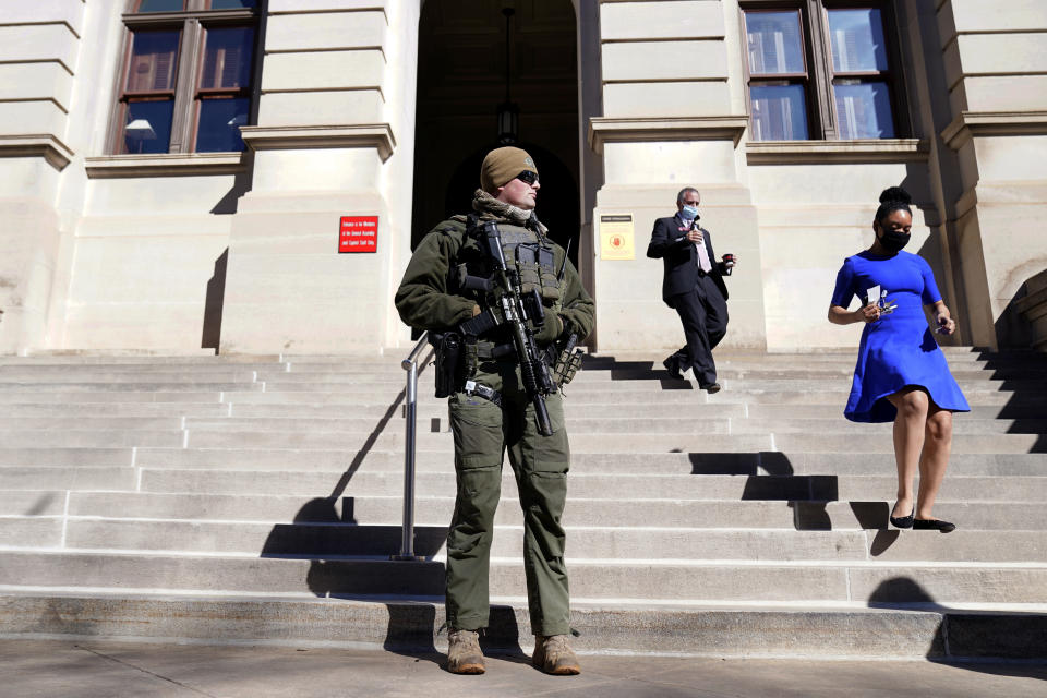 A Georgia State Patrol S.W.A.T. team member stands guard outside the Georgia State Capitol building Thursday, Jan. 14, 2021, in Atlanta. With the FBI warning of potential violence at all state capitols Sunday, Jan. 17, the ornate halls of government and symbols of democracy looked more like heavily guarded U.S. embassies in war-torn countries. (AP Photo/John Bazemore)