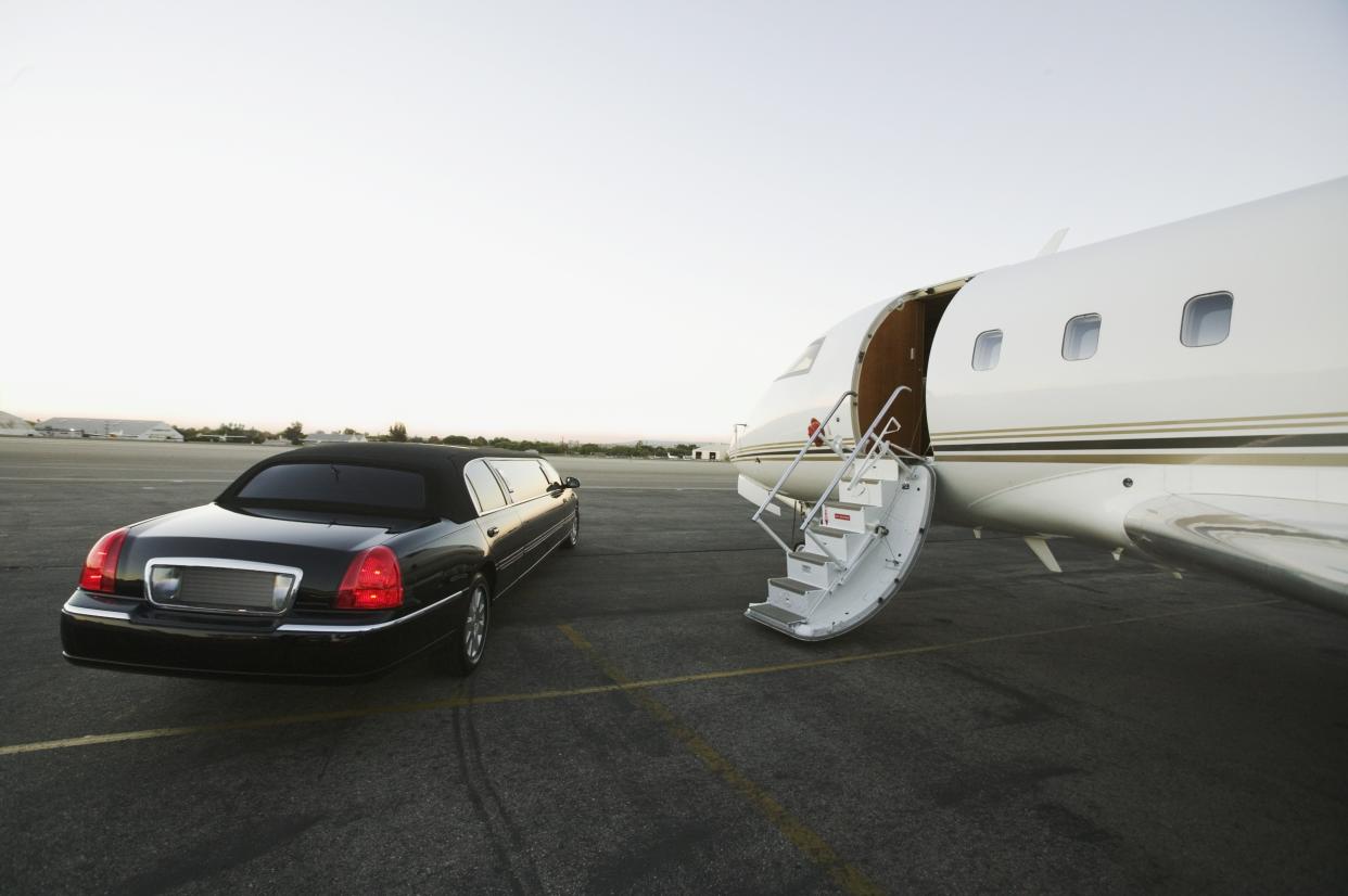 Stretch limo parked beside airplane