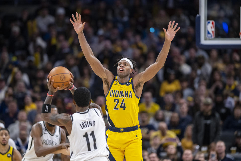 Indiana Pacers guard Buddy Hield (24) defends Brooklyn Nets guard Kyrie Irving (11) during the second half of an NBA basketball game in Indianapolis, Friday, Nov. 25, 2022. (AP Photo/Doug McSchooler)