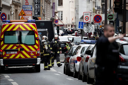 French police and firefighters secure the street as a man has taken two people hostage at a business in Paris, France, June 12, 2018. REUTERS/Benoit Tessier