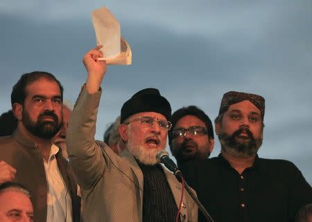 Tahir ul-Qadri, Sufi cleric and leader of political party Pakistan Awami Tehreek (PAT), displays a document to supporters while speaking to them in front of the Parliament House building during the Revolution march in Islamabad August 28, 2014. REUTERS/Faisal Mahmood