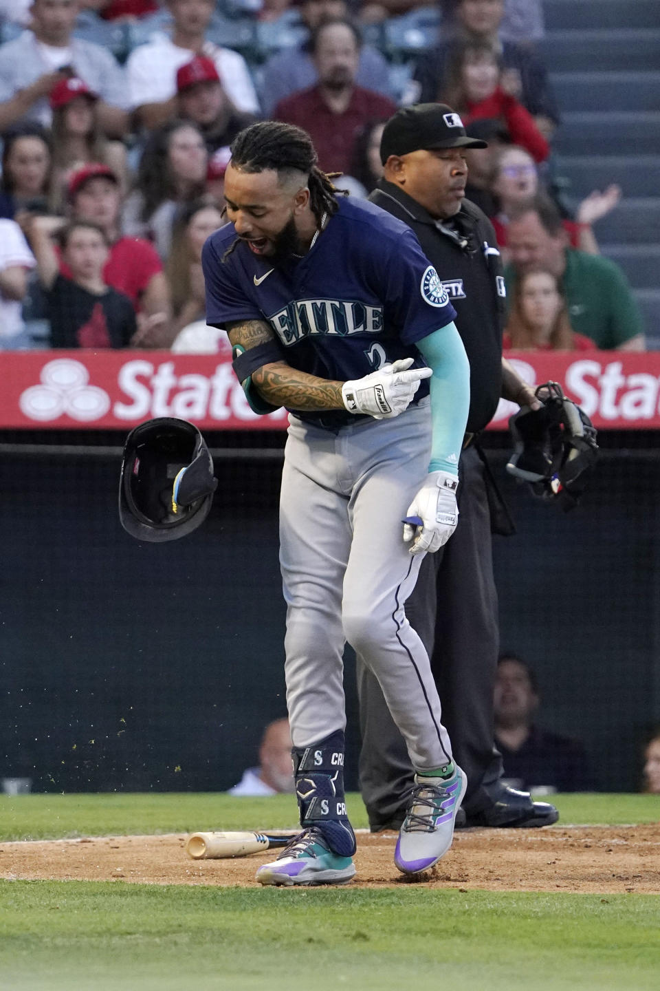 Seattle Mariners' J.P. Crawford, left, reacts after striking out as home plate umpire Adrian Johnson stand behind during the second inning of a baseball game against the Los Angeles Angels Saturday, June 25, 2022, in Anaheim, Calif. (AP Photo/Mark J. Terrill)