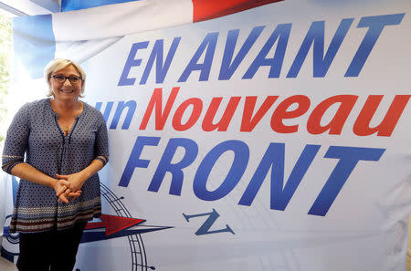 FILE PHOTO - Member of parliament Marine Le Pen of France's far-right National Front (FN) political party poses near a banner of her party in Toulouse, Southwestern France, September 23, 2017. Banner reads Forward for a new Front (National). REUTERS/Regis Duvignau/File Photo