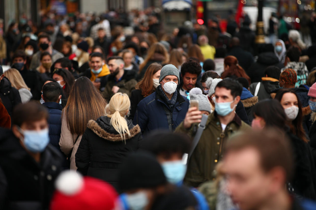 Shoppers, some wearing face masks, walk along a busy Oxford Street in London. (Getty)