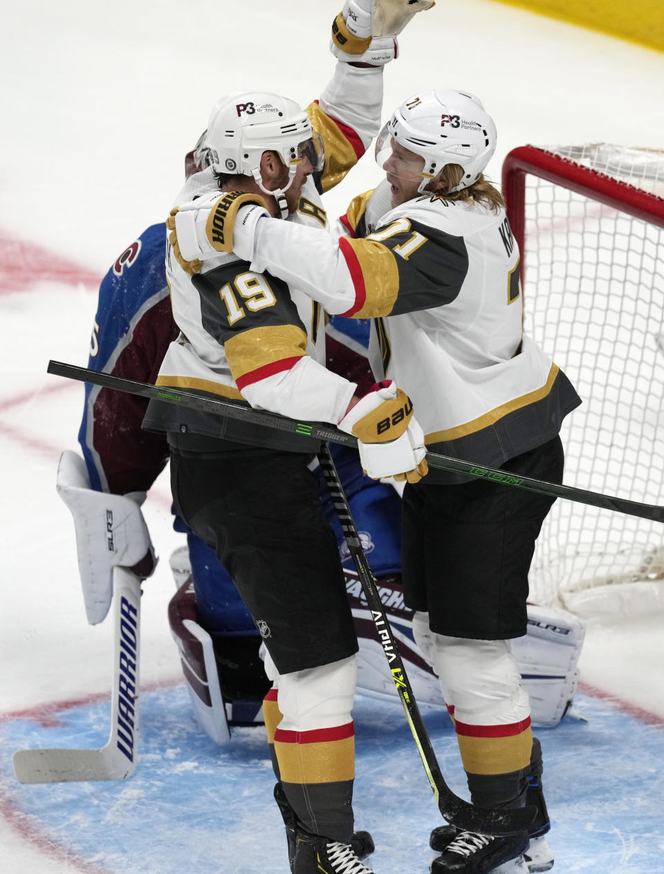 Vegas Golden Knights center William Karlsson, front right, celebrates scoring a goal with right wing Reilly Smith, front left, against Colorado Avalanche goaltender Darcy Kuemper, back, in the first period of an NHL hockey game Tuesday, Oct. 26, 2021, in Denver. (AP Photo/David Zalubowski)