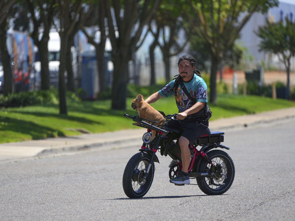 Chris Del Rosario, socio de un negocio de cría de bulldog francés con su hermano, Jaymar Del Rosario, conduce con una macana y una pistola por si alguien se atreve a robar a su perro Cashew, en Elk Grove, California, el 18 de mayo de 2022. (Jim Wilson/The New York Times)
