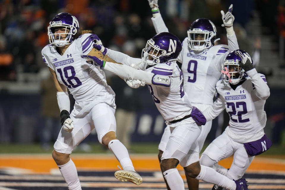 Northwestern defensive back Garner Wallace (18) celebrates after recovering a fumble by Illinois and running in a touchdown during the second half of an NCAA college football game Saturday, Nov. 25, 2023, in Champaign, Ill. (AP Photo/Erin Hooley)