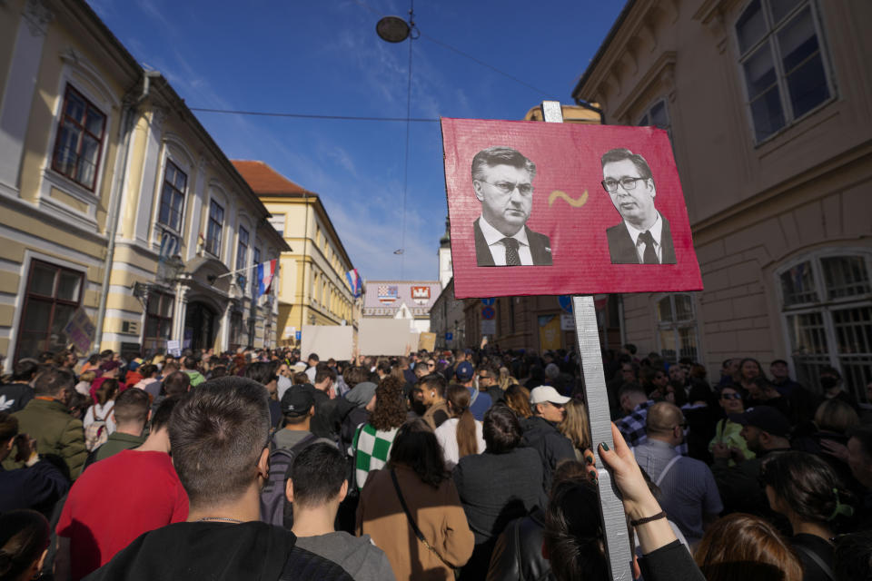 An anti-government protester holds a banner that shows Croatia's Prime Minister Andrej Plenkovic, left, and Serbian President Aleksandar Vucic, during a protest at the St. Mark square in Zagreb, Croatia, Saturday, Feb. 17, 2024. Thousands of people joined an anti-government rally in Croatia accusing the ruling center-right party of corruption and demanding that this year's parliamentary election be held as soon as possible. (AP Photo/Darko Bandic)