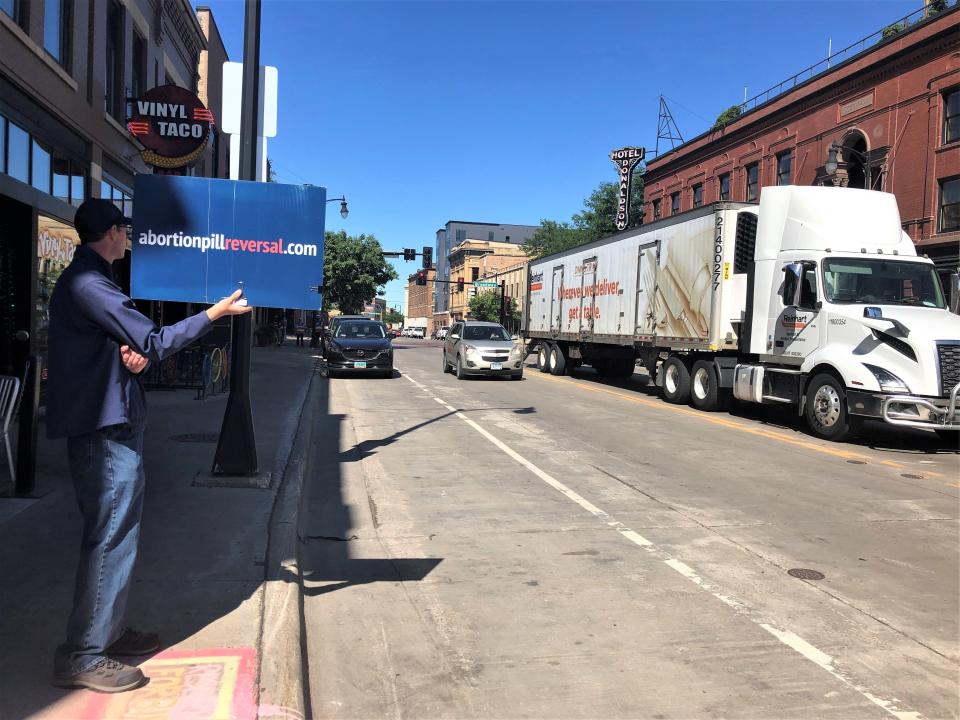 A longtime abortion protester, who refused to give his name, stands outside the Red River Women’s Clinic in downtown Fargo, N.D., on Wednesday, July 27, 2022, in what was supposed to be the last scheduled day for medical procedures in a state that has banned abortions. A judge late Wednesday issued an order that will delay the state’s trigger law from going into effect for at least another month. (AP Photo/Dave Kolpack)